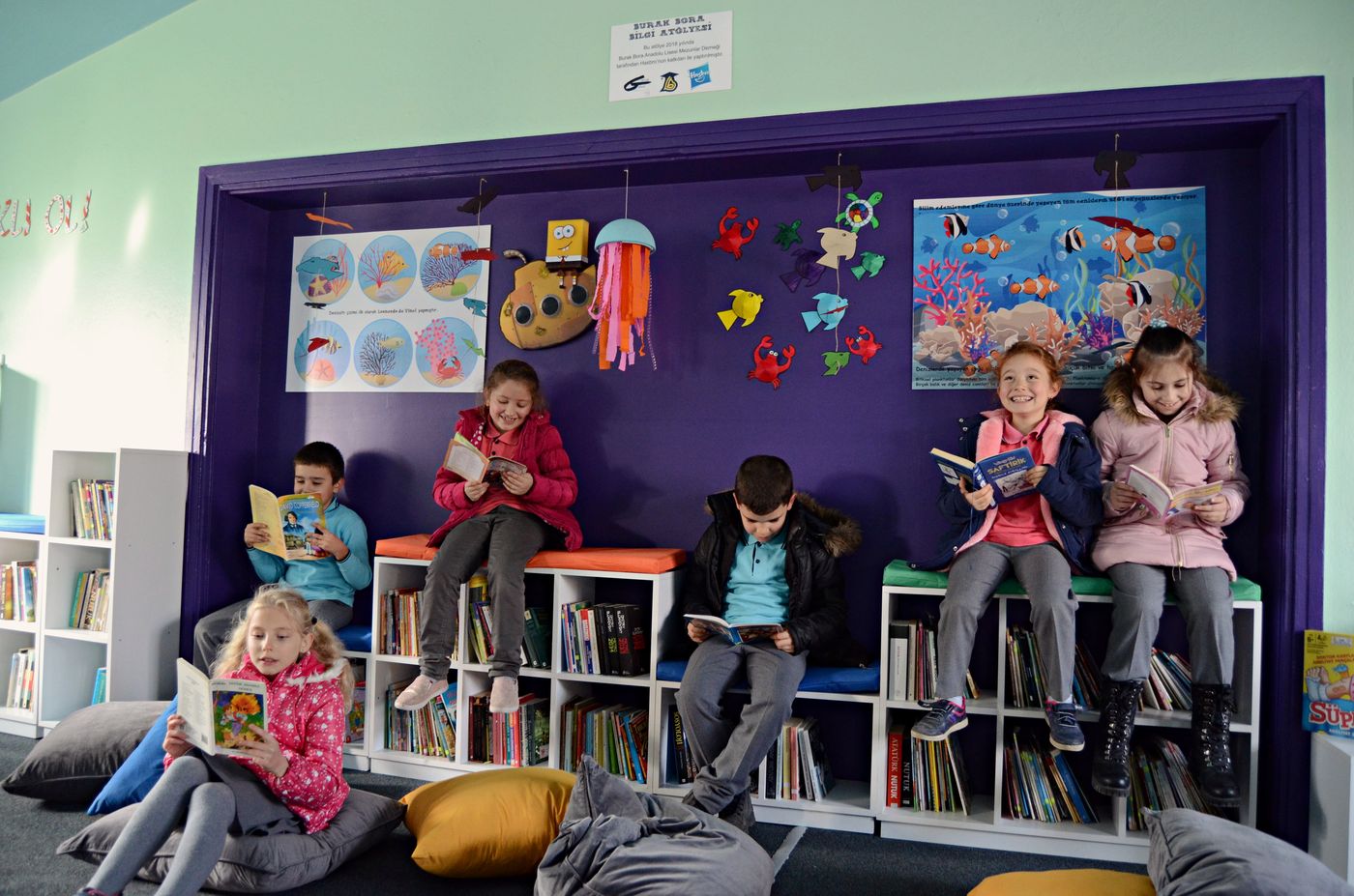 Burak Bora Kütüphanesi'nde kitap okuyan çocuklar